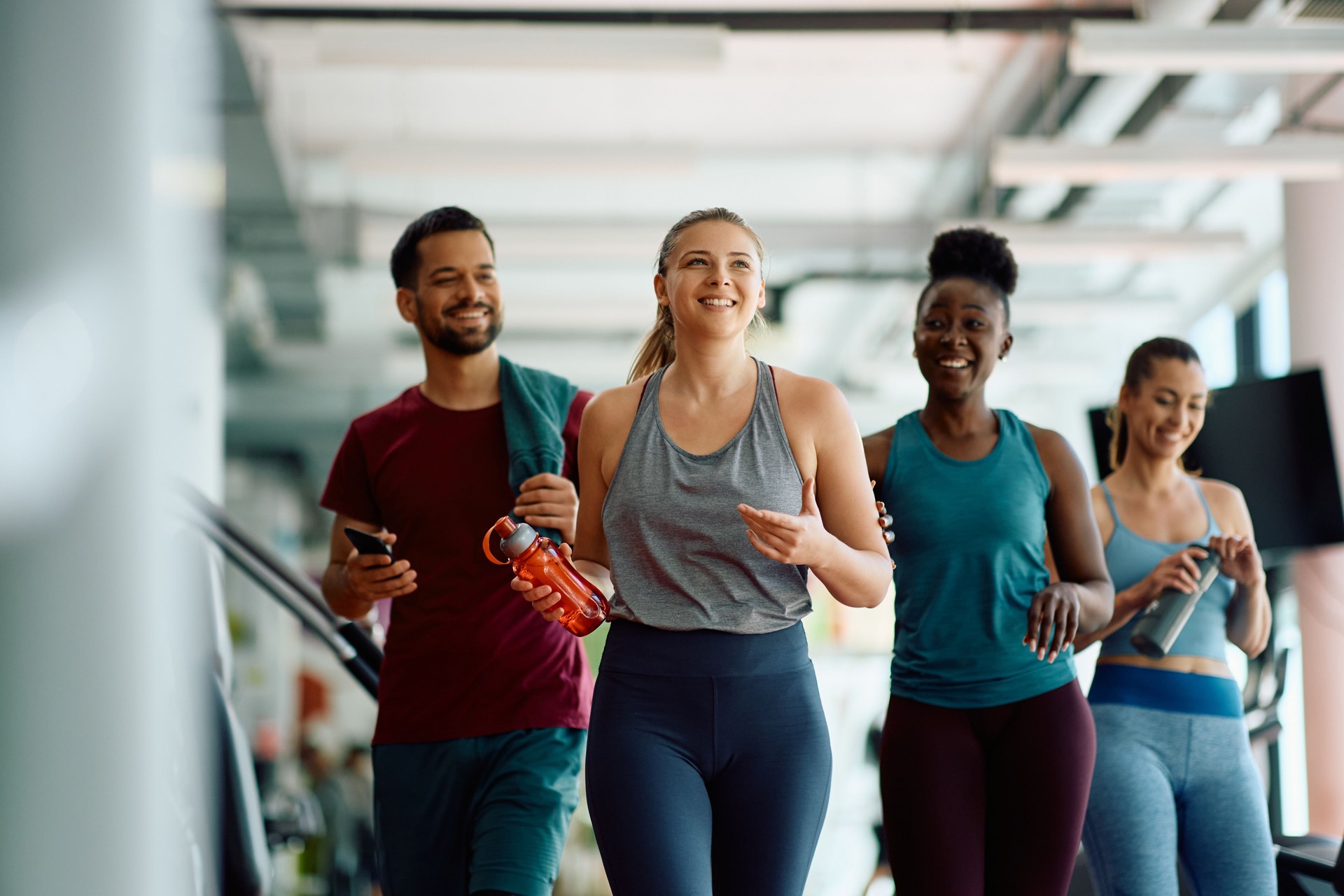 Happy athletic woman and her friends exercising in a gym.